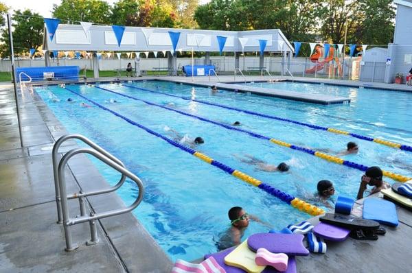 Our swim team kids hard at work perfecting their strokes! Playground visible, Barbeque  area not pictured.