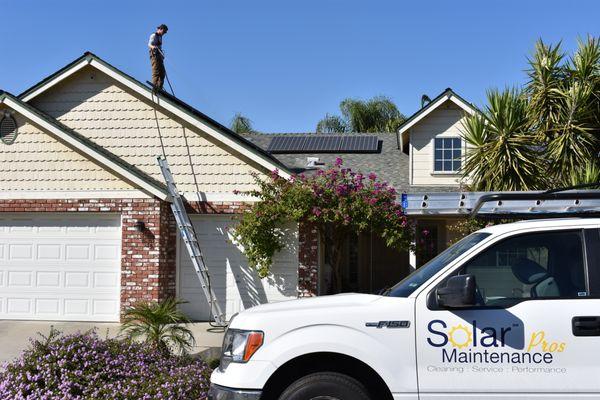 Crew member Cameron Voss rinsing off system after performing a panel cleaning on Soft Rock 98.9 Teri Ann's Fresno home.