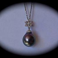 Black Tahitian pearl mounted in white gold diamond flower