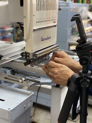 Threading the embroidery machine.