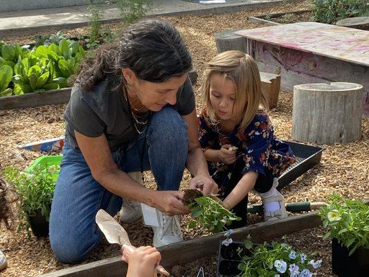 Kindergarten teacher and student in garden