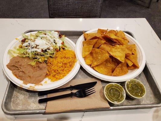 Chips, green salsa and enchilada with rice and beans.