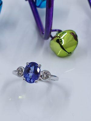 Oval Tanzanite set in 14k white gold ring with two round diamonds