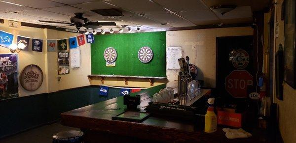 Nice darts set up on the left side behind bar.