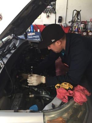 Ricky adjusting head valve on a car.