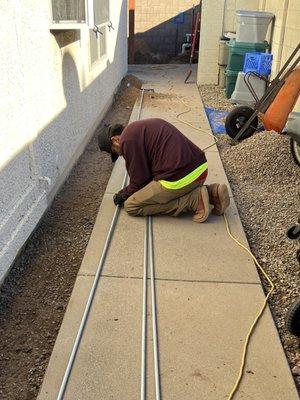 Running the conduit along the upper slab from the main panel to the pump.