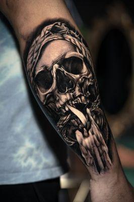 Black and grey realistic tattoo of a skull