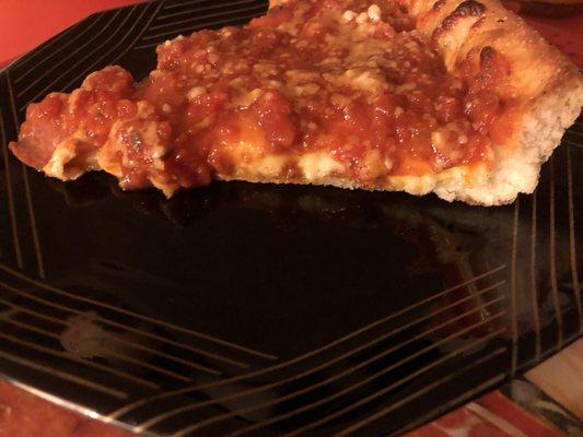 Close up of a slice of Chicago style pizza. Not very thick and very little pepperoni.