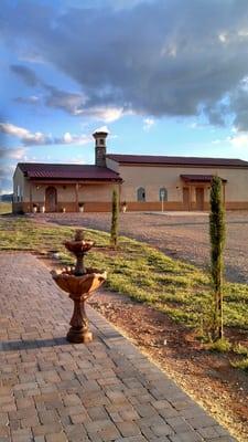 Standing on the Boccie ball court looking at the Tuscan-style winery during sunset.