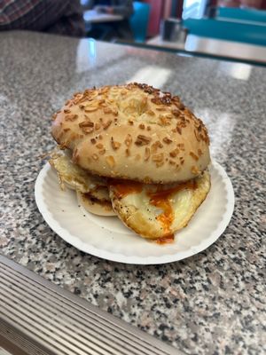 sausage egg and cheese on an onion bagel grilled