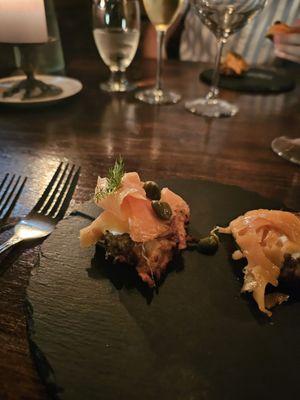 Delicious appetizers - potato pancakes with a tzatziki sauce, smoked salmon, dill and capers