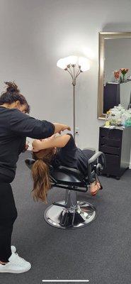 An employee doing Eye Brow Threading service.