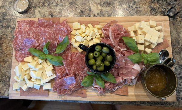 A charcuterie board put together with assorted meats and cheeses from Lombardis. Zoom in to se ether names of the meats and cheeses.