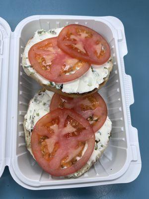 Open face everything bagel, toasted with scallion cream cheese and tomato