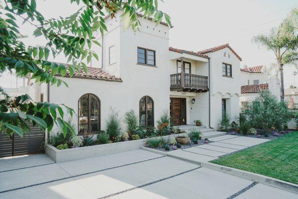 Sand finish concrete driveway and pavers with pebble channels.  Drought tolerant plantings.