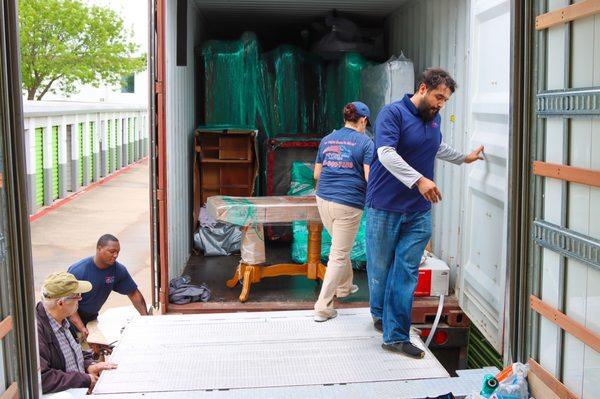 Crew packing and loading container. Customer amazed by how well it was packed. He doubted all would fit.