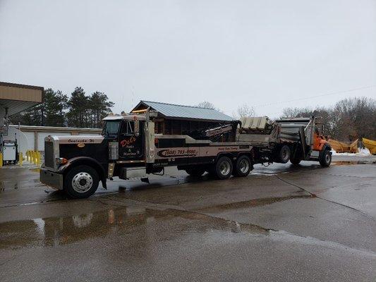 25 ton wrecker towing a county plow