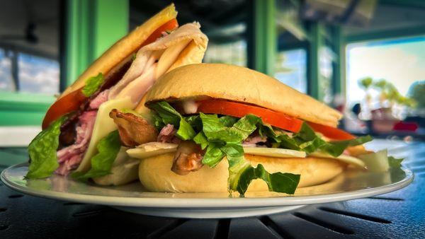 Clubhouse Sandwich | Freshly shaved smoked turkey & ham, bacon, lettuce, tomato, Swiss, cheddar & honey mustard on grilled Cuban roll