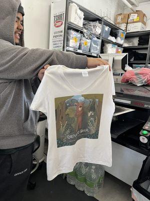 Jamar pulls out t shirt from printer, then puts it in press.