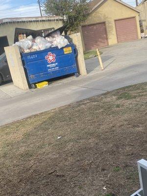 Over flowing trash bin located right outside if residents door