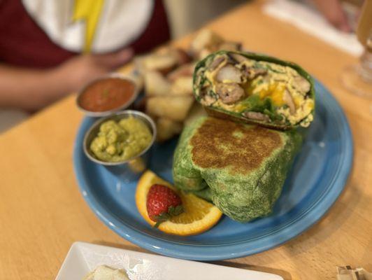 Breakfast wrap w/ link sausage guacamole & salsa and a side of potatoes.