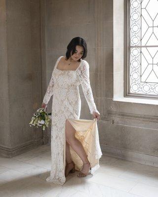 Asian bride fixing her wedding dress at SF City Hall