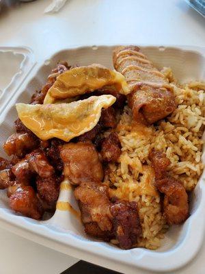 Fried rice with general tso chicken, chicken dumplings, and an egg roll.