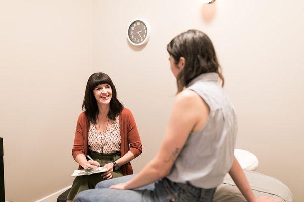 Acupuncturist Julia discussing health history during a private session