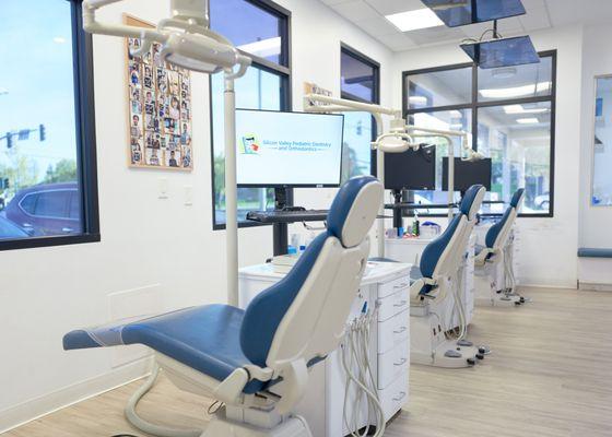 Bright natural light filled orthodontic treatment bays with personalized overhead TVs for patient entertainment