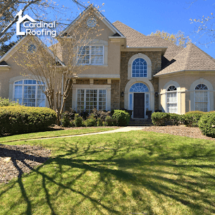 Large home with brown siding and brick and a tan asphalt shingle roof.