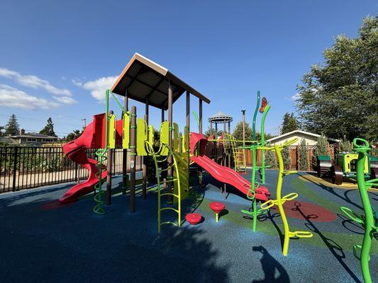 Zoomed out view of older playground. In the back, you can see the community garden.