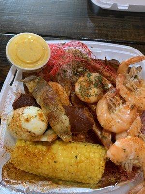 Steamed shrimp, crab legs, corn, potato, boiled egg, sausage, butter