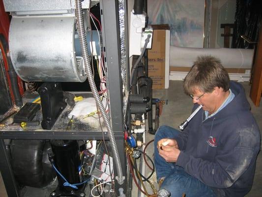 Chris Birkley doing a repair on a Geothermal unit