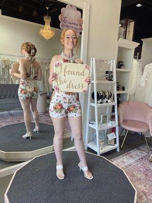 Photo in boutique w/ "I found the dress" sign