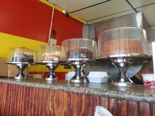 gorgeous layer cakes line the front counter, to be sold by the slice