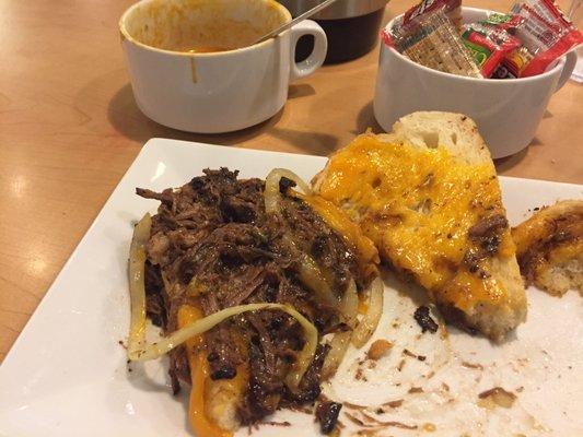 Opened pot roast grilled cheese sandwich. Soup bowl in back. Cheese on both sides of bread. Pot roast was delicious and tender. Nice portion