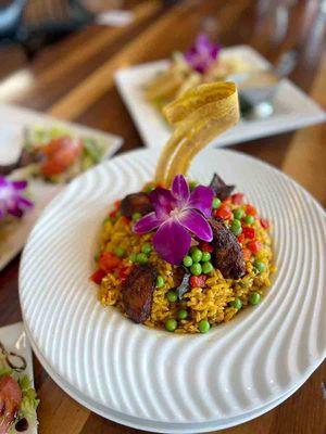 Arroz con Pollo
 
 Traditional cuban chicken with valencia yellow rice garnished with peas, roasted peppers and fried sweet plantains