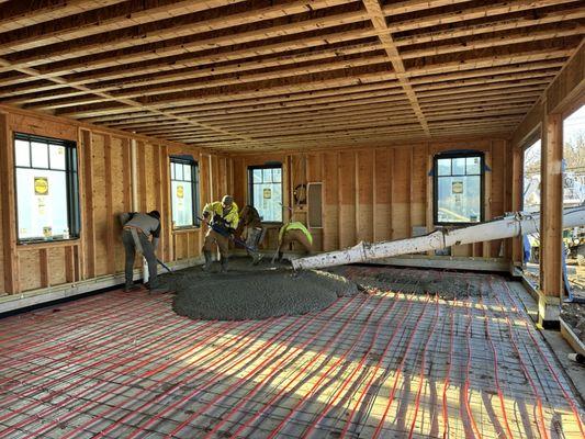 Concrete being poured on the radiant heat pipes