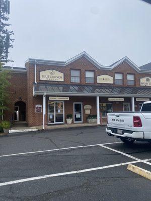 Front of bakery and parking lot, small outdoor seating area is to the side