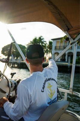 Captain driving boat in Fort Lauderdale for a Sunset Cruise.