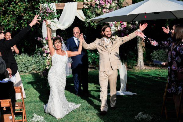 Bride and groom walking down aisle together.