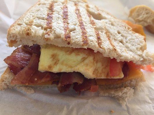 Bacon, egg, cheese, and tomato breakfast sandwich