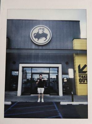 My friend in front of buffalo wild wings with a thumbs down and the bird!