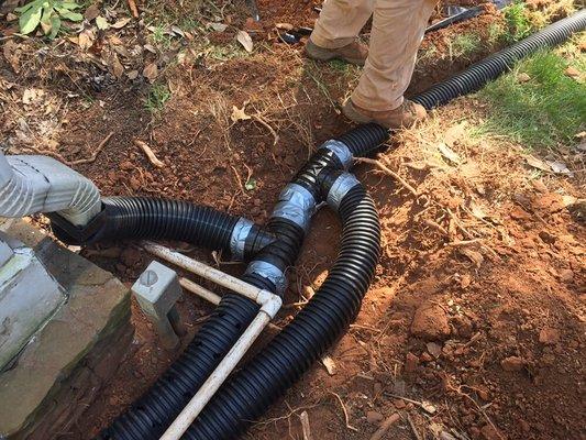 We install smooth core downspout drain lines and large hole surface French drain systems.