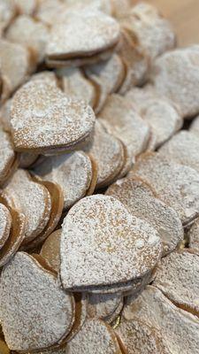 ALFAJORES - Two buttery, melt-in-the-mouth cookies filled with creamy caramel & topped w/ sprinkled powdered sugar.