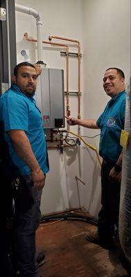 Elite Rooter technicians working together on a plumbing installation, ensuring everything is set up with precision and care.