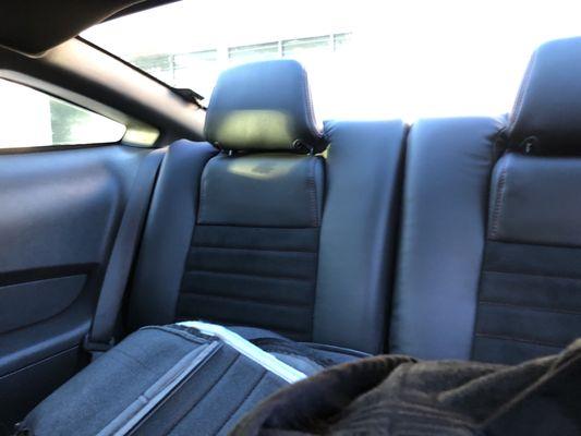 Rear seats in black leather with black suede insert and red stitching.