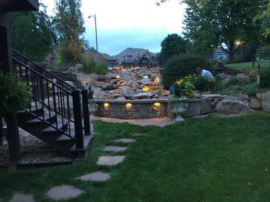 Stream water feature with reflection pond surrounded by bench