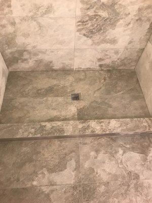 Custom built shower with porcelain on floor and one wall