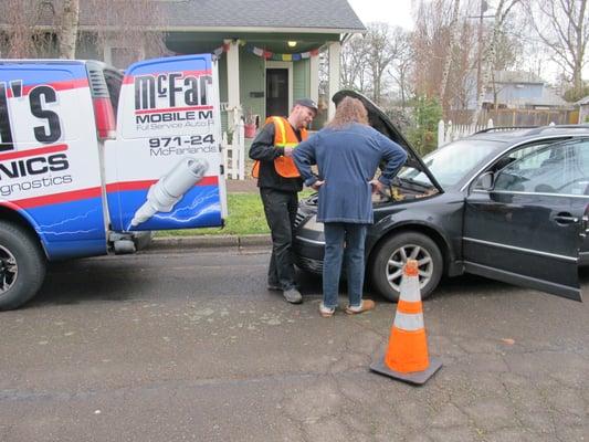 Kevin McFarland assisting a customer with her vehicle at her home.